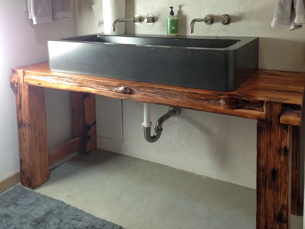 Reclaimed wood bathroom vanity with stone farmhouse sink by Green Wood Milling Co.