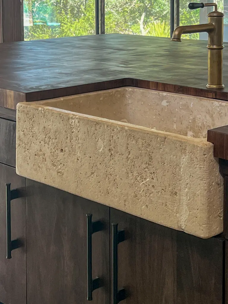 Custom stone farmhouse sink with herringbone wood countertop