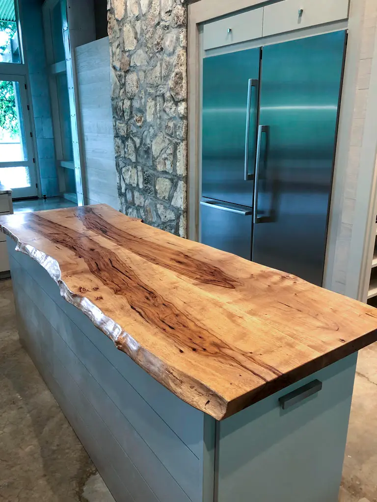 Live edge slab countertop on blue-gray kitchen island