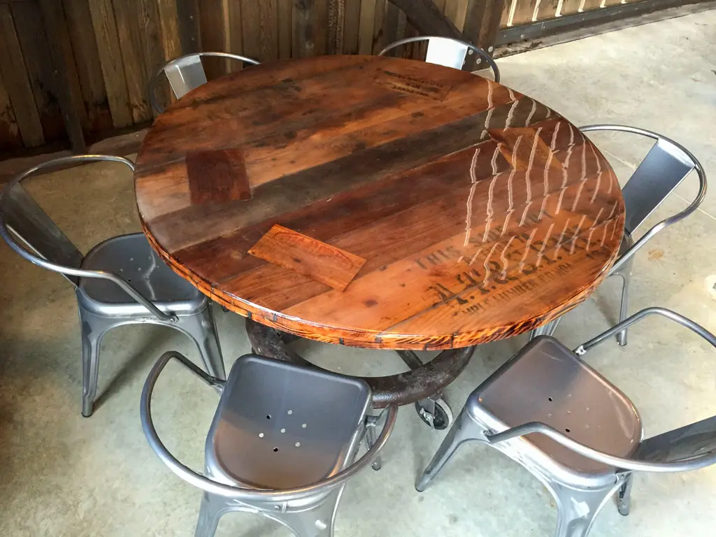 Round reclaimed wood dining table with industrial metal chairs