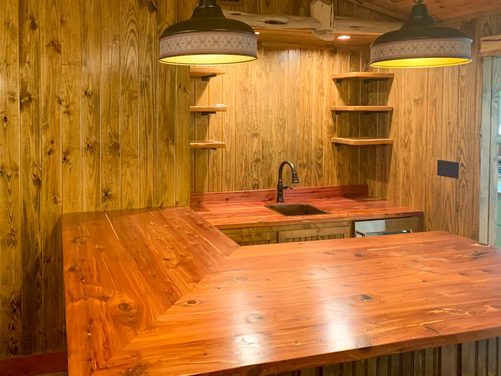 Custom wood bar countertop with corner sink and floating shelves
