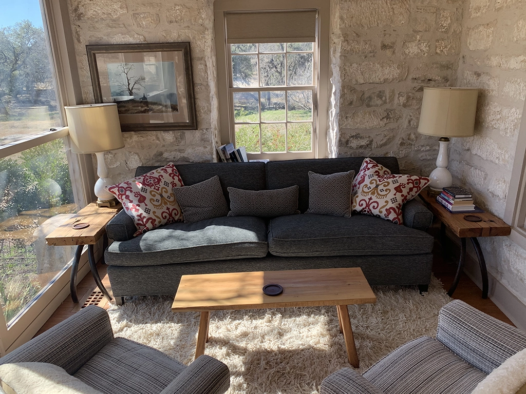 Rustic wood coffee table and side tables in stone wall living room
