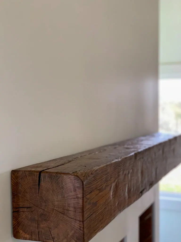 Rustic beam mantle installed on wall by Green Wood Milling Co.