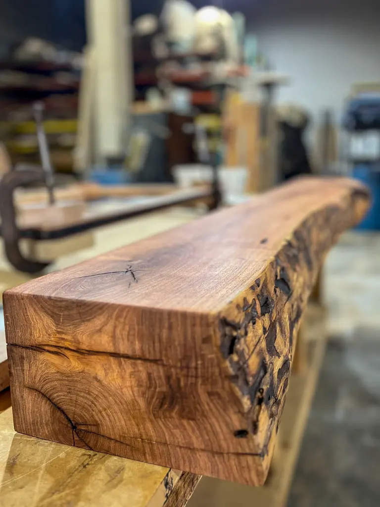 Live edge mantle with natural bark edge in workshop at Green Wood Milling Co.