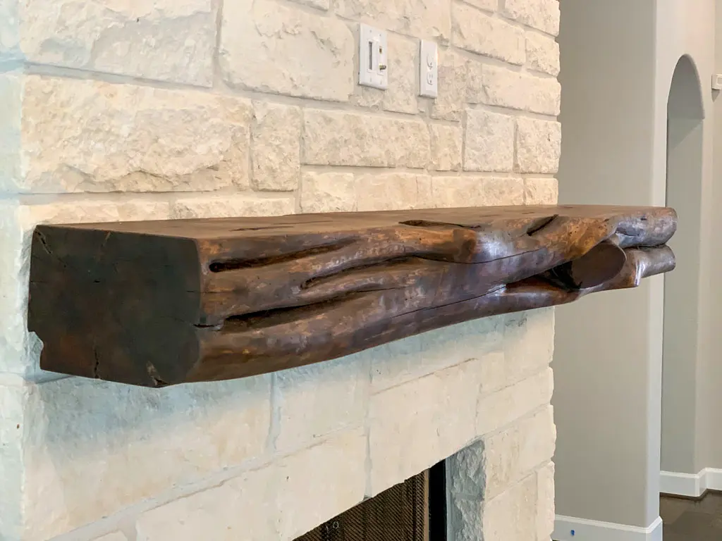 Rustic beam mantle on limestone fireplace by Green Wood Milling Co. in San Antonio