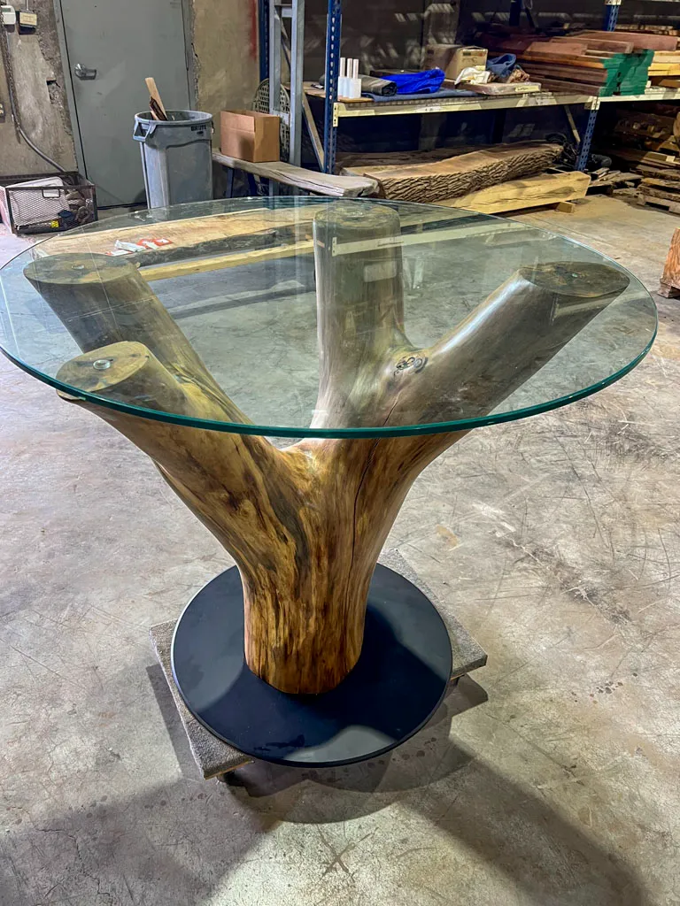 Tree trunk base table with glass top for outdoor patio use