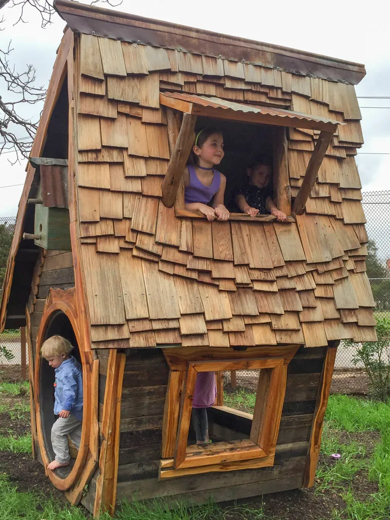 Custom wooden playhouse with children playing inside
