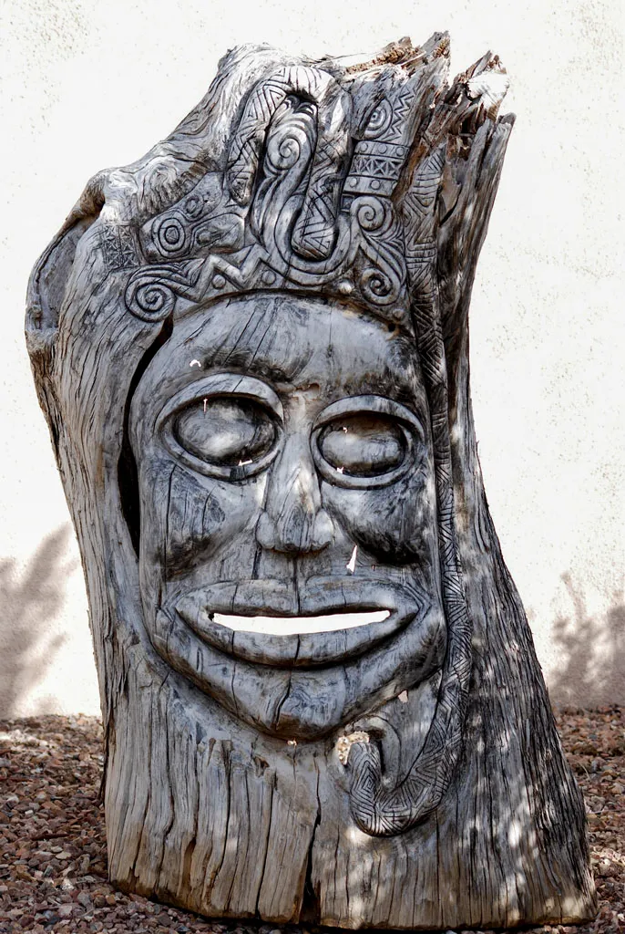 Hand-carved tribal face sculpture from tree stump in San Antonio