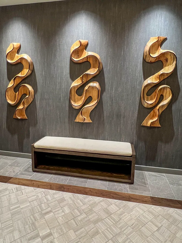Lobby wall sculptures with cushioned bench by Green Wood Milling Co.
